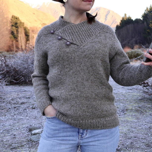 Women wearing a undyed wool and mohair pullover with large button collar standing in frosty landscape