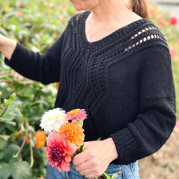 Women picking flowers wearing black cotton sweater with geometric lacework motif