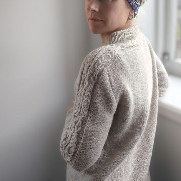 Hand knitted sweater in marigold colour with cable details along the sleeve and upper back