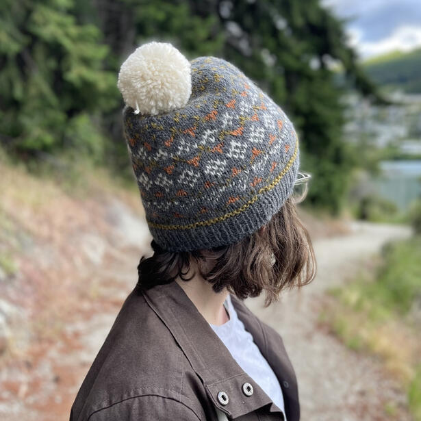 Girl wearing knitted colorwork beanie with pompom
