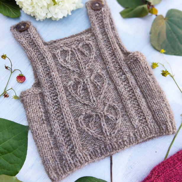 Knitted Baby vest in possum and wool yarn with heart-shaped kawakawa leaf motif